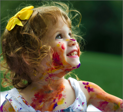 Image of a toddler girl with paint on her face and body